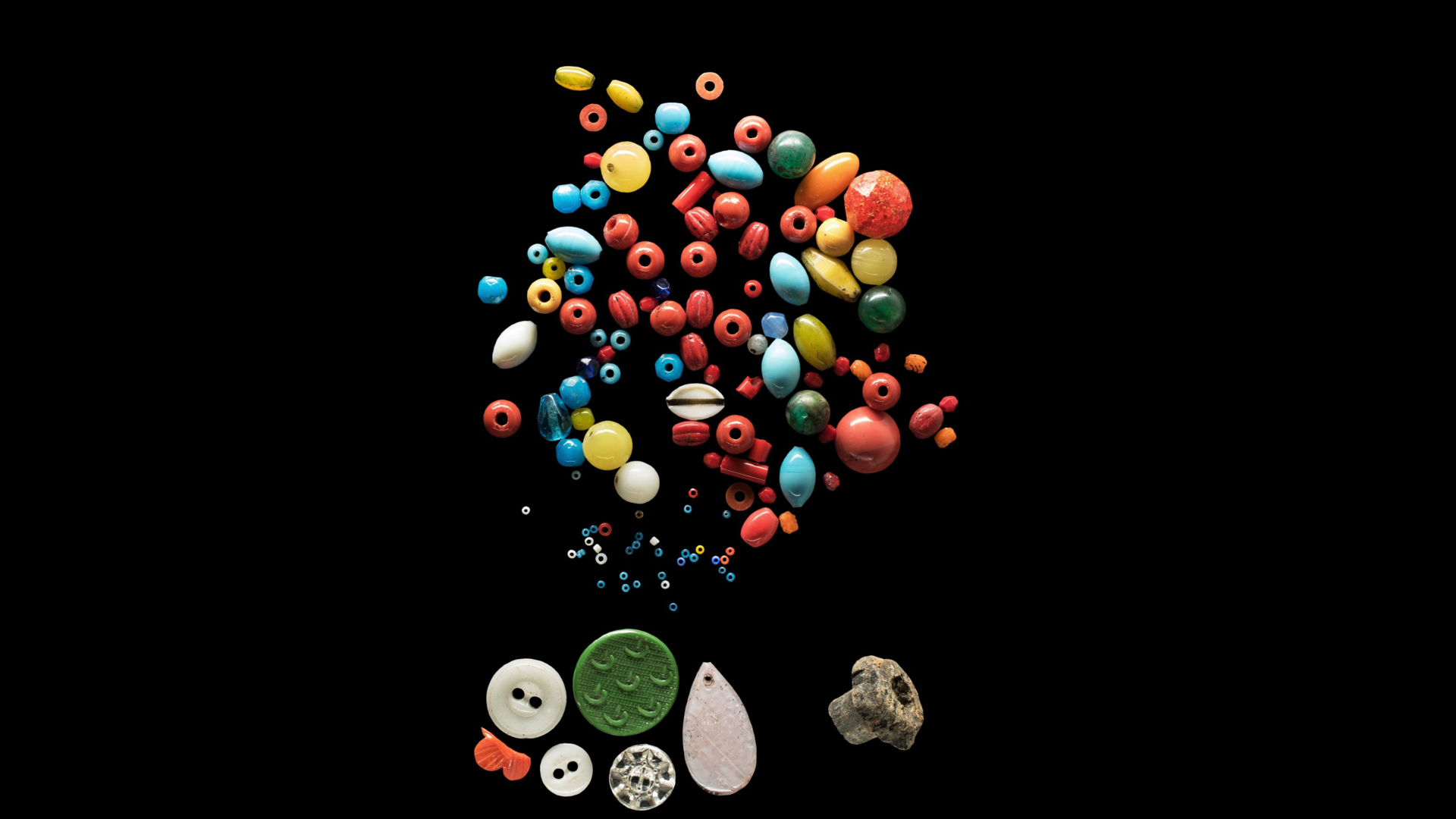 Bunte Perlen und Knöpfe auf schwarzem Hintergrund